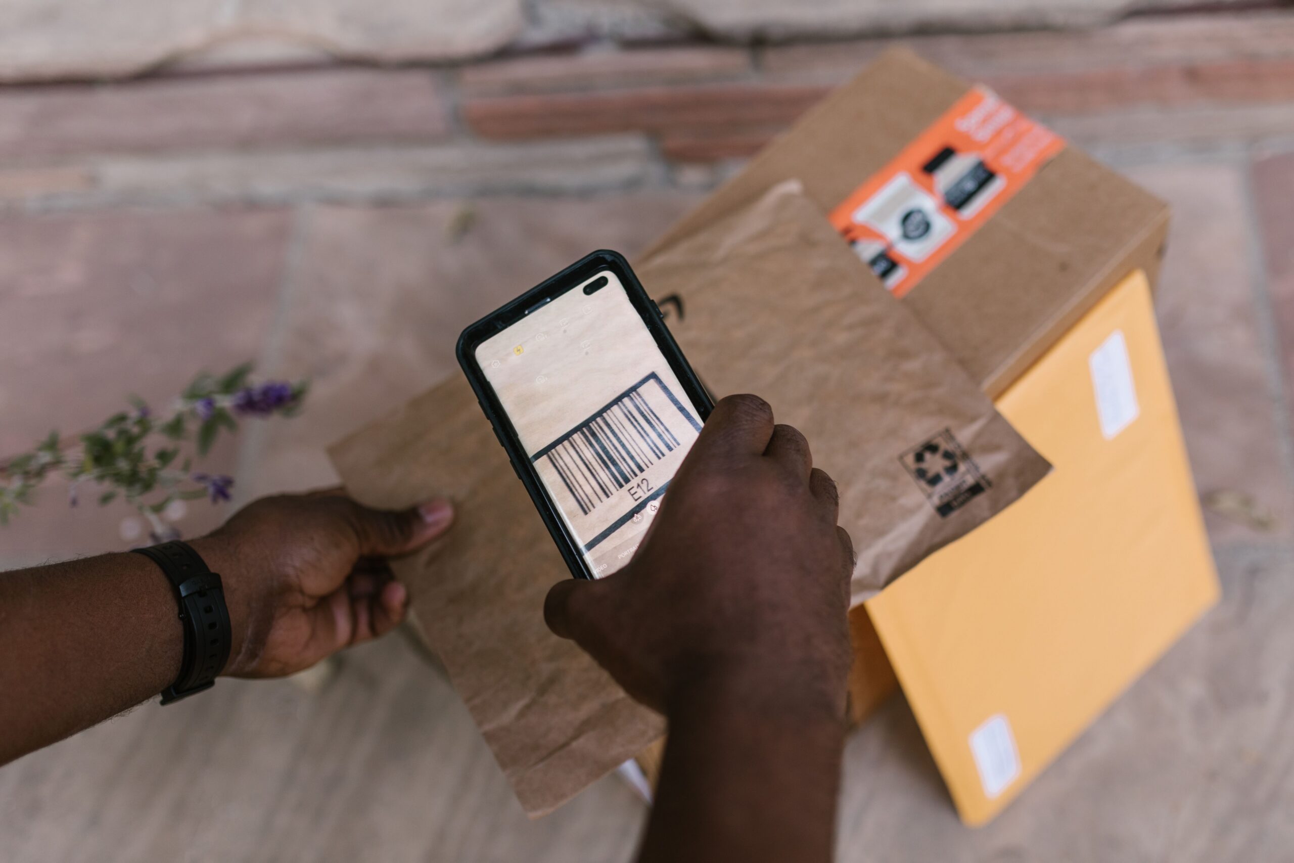 Um empreendedor utilizando um celular para ler um QR Code de pagamento em um balcão de loja.